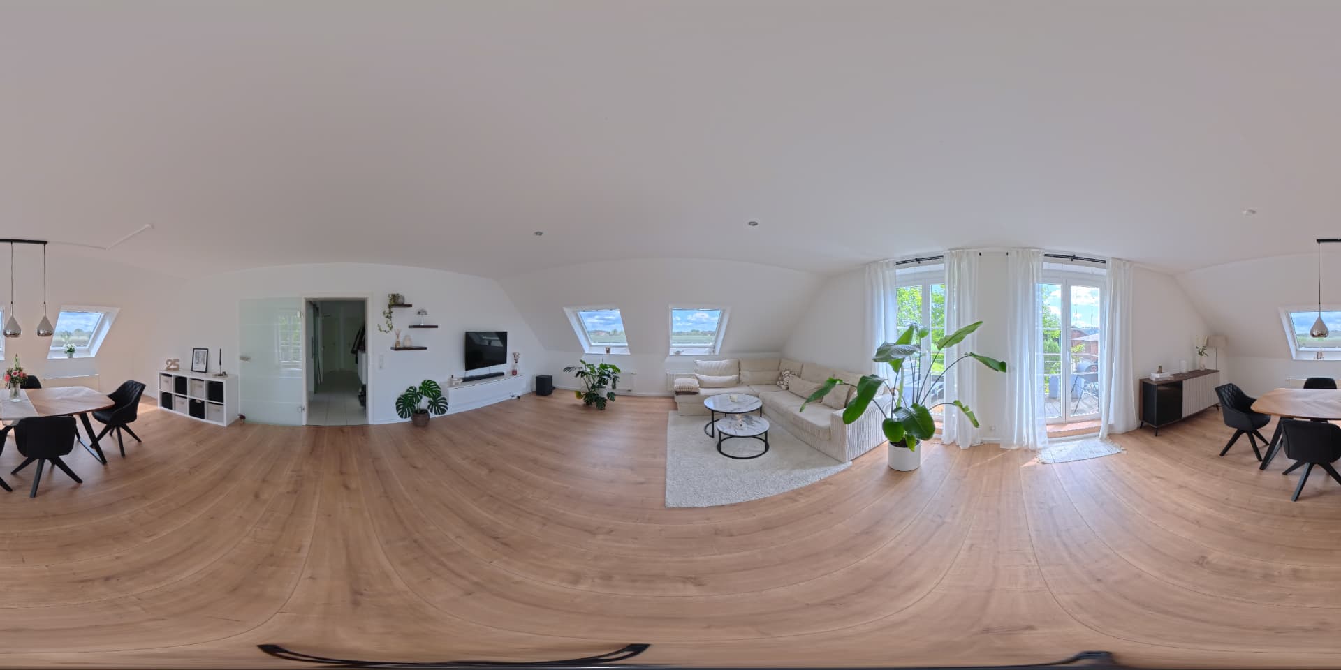 360°-Aufnahme einer hellen Wohnung mit Holzboden, Sofaecke und Dachschräge